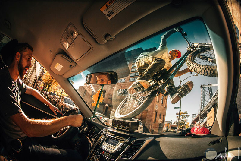 صورة اكشن لشخص يمشى فوق زجاج السيارة بدراجتة