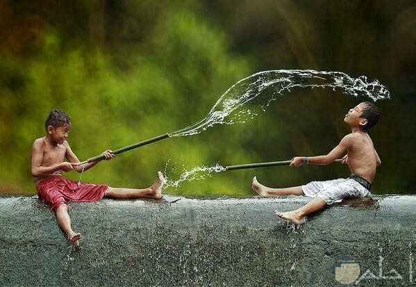 صورة أطفال واللعب بالماء ودقة تصوير القطرات