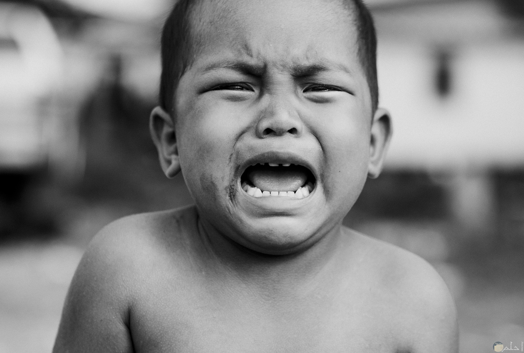 صورة حزينة بالأبيض والأسود لطفل حزين ويبكي