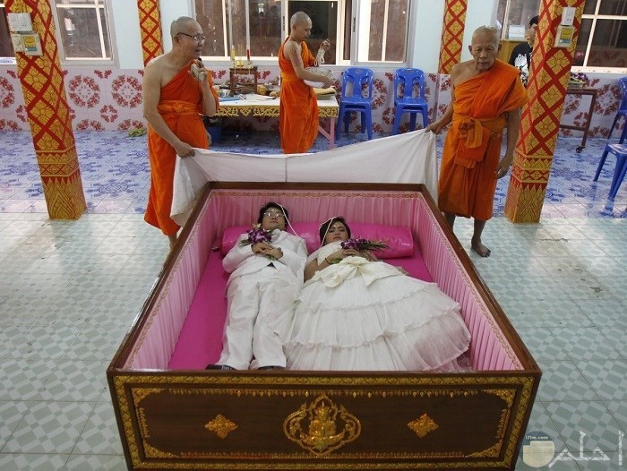 عروسان من تايلاند داخل تابوت في يوم زفافهما؛ لاعتقادهما أن ذلك سيبعد عنهما الحظ السيء، ويجلب السعادة.