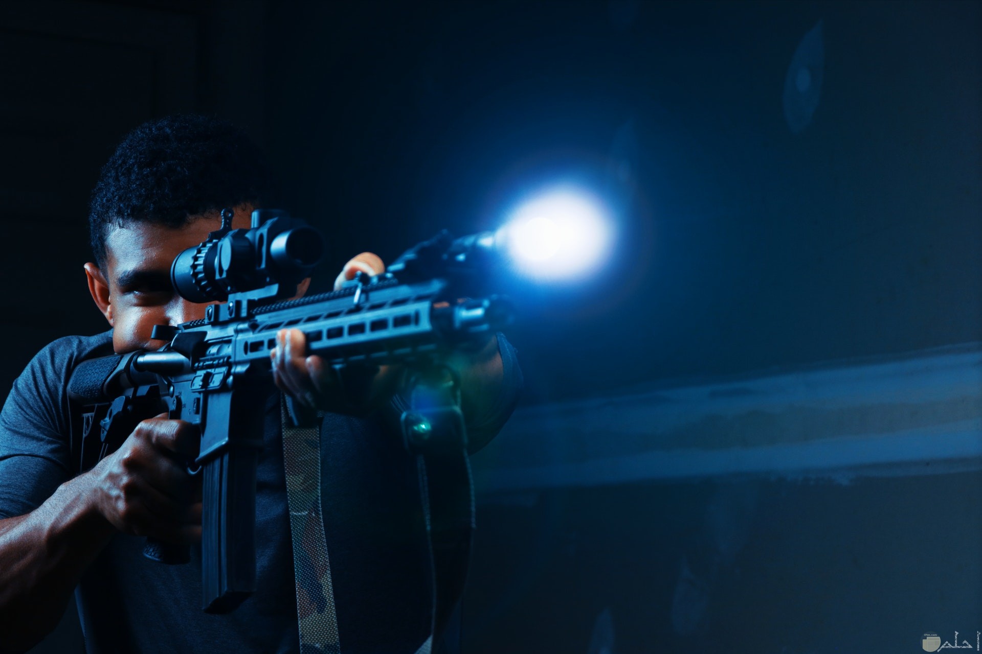 صورة أكشن مميزة لشاب يحمل سلاح في الظلام