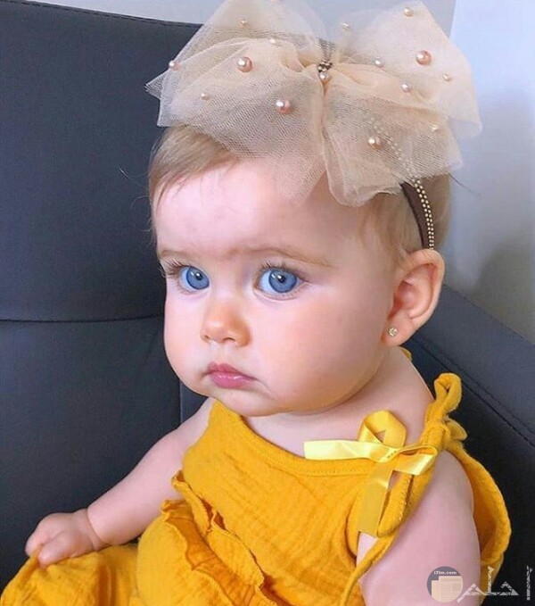 صورة جميلة جدا لبنت صغيرة جالسة بفستان أصفر حلو