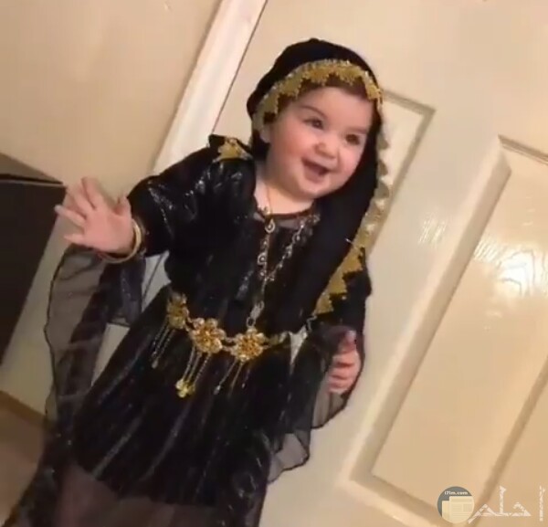 صورة جميلة جدا لبنت صغيرة واقفة مرتديه فستان أسود مزين حلو