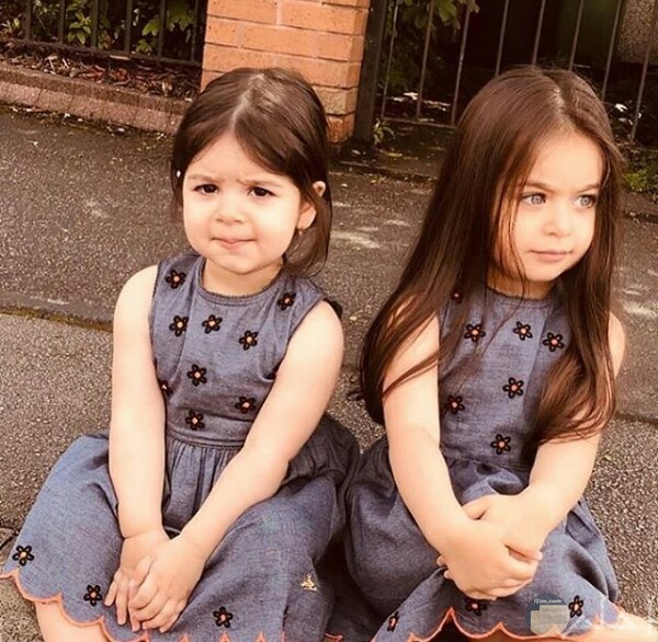 صورة جميلة جدا لبنتين صغيرتين جالستان علي الأرض بفستان حلو