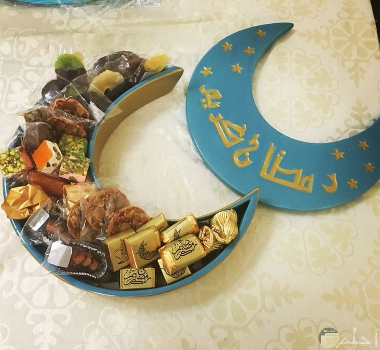 صورة جميلة للتهنئة بشهر رمضان فيها علبة حلويات لذيذة مكتوب علي غطائها رمضان كريم