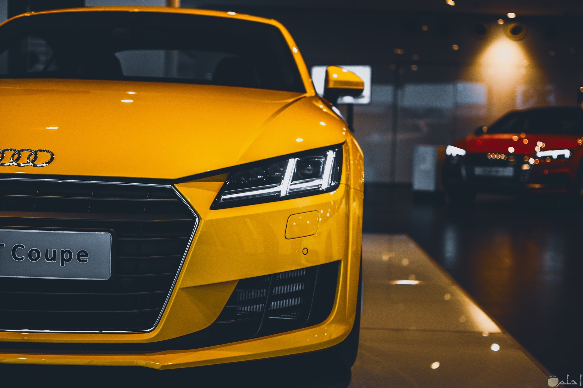 صورة سيارة أودي صفراء فخمة جميلة ومميزة جدا خلفها سيارة حمراء