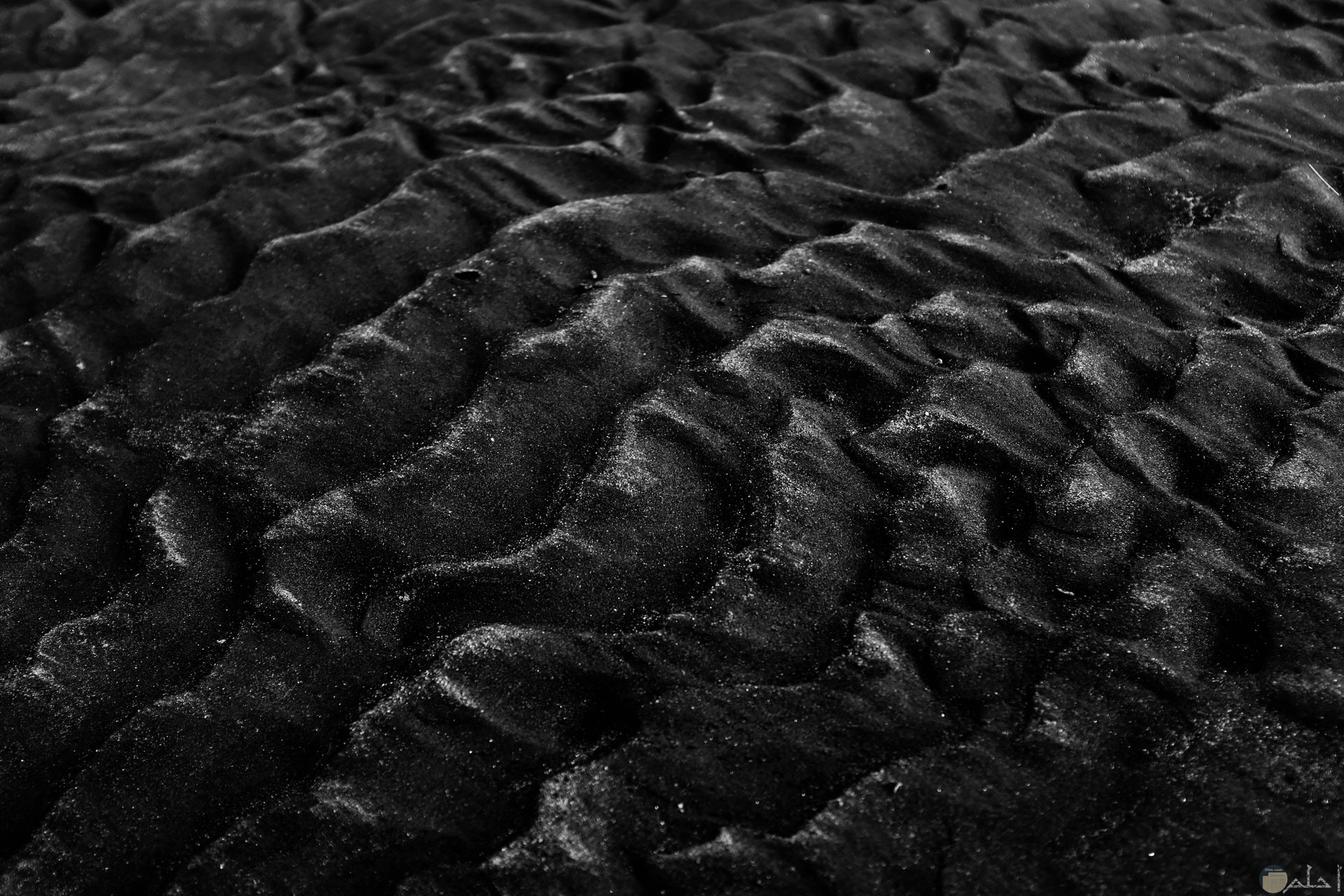 صورة غريبة لرمال الشاطئ باللون الأسود علي غير العادة