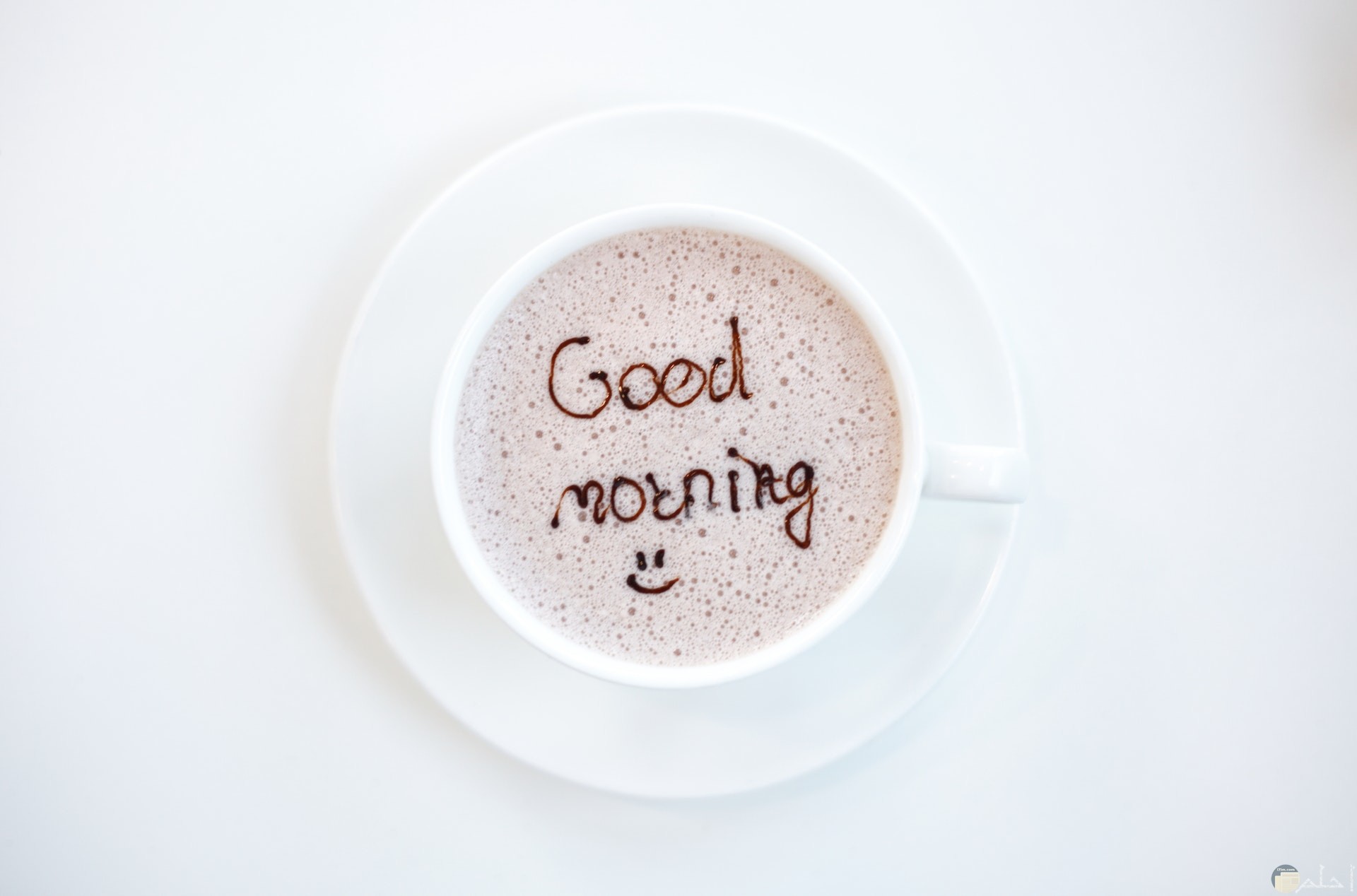 صورة لتحية الصباح بالإنكليزية مكتوبة داخل فنجان القهوة معها ايموشن مبتسم