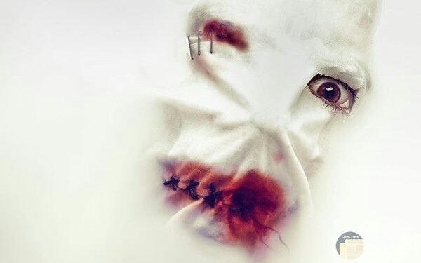 صورة مخيفة لشخص يرتدي قناع أبيض وفمه مخيط وبه دماء وعينه اليمني مصابة