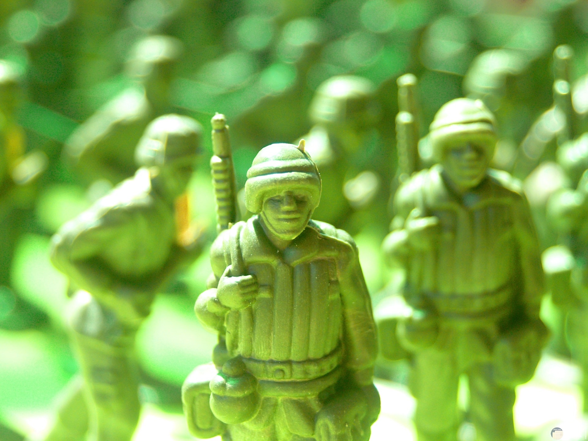 صورة مميزة لألعاب أطفال ولاد عن لعب جنود باللون الأخضر في حرب وخلفهم جنود أخرين