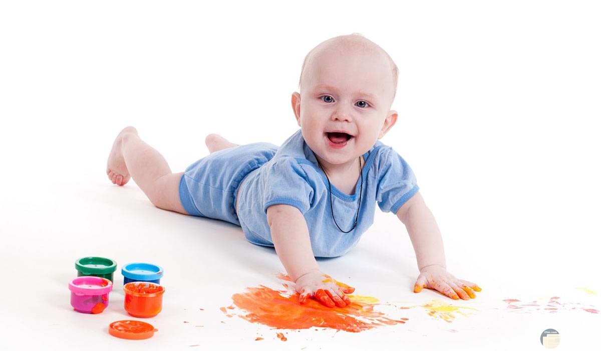 طفل صغير يلعب بالألوان.