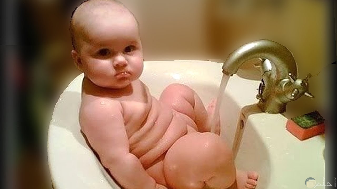 طفل يجلس داخل حوض الحمام بشكل مضحك.