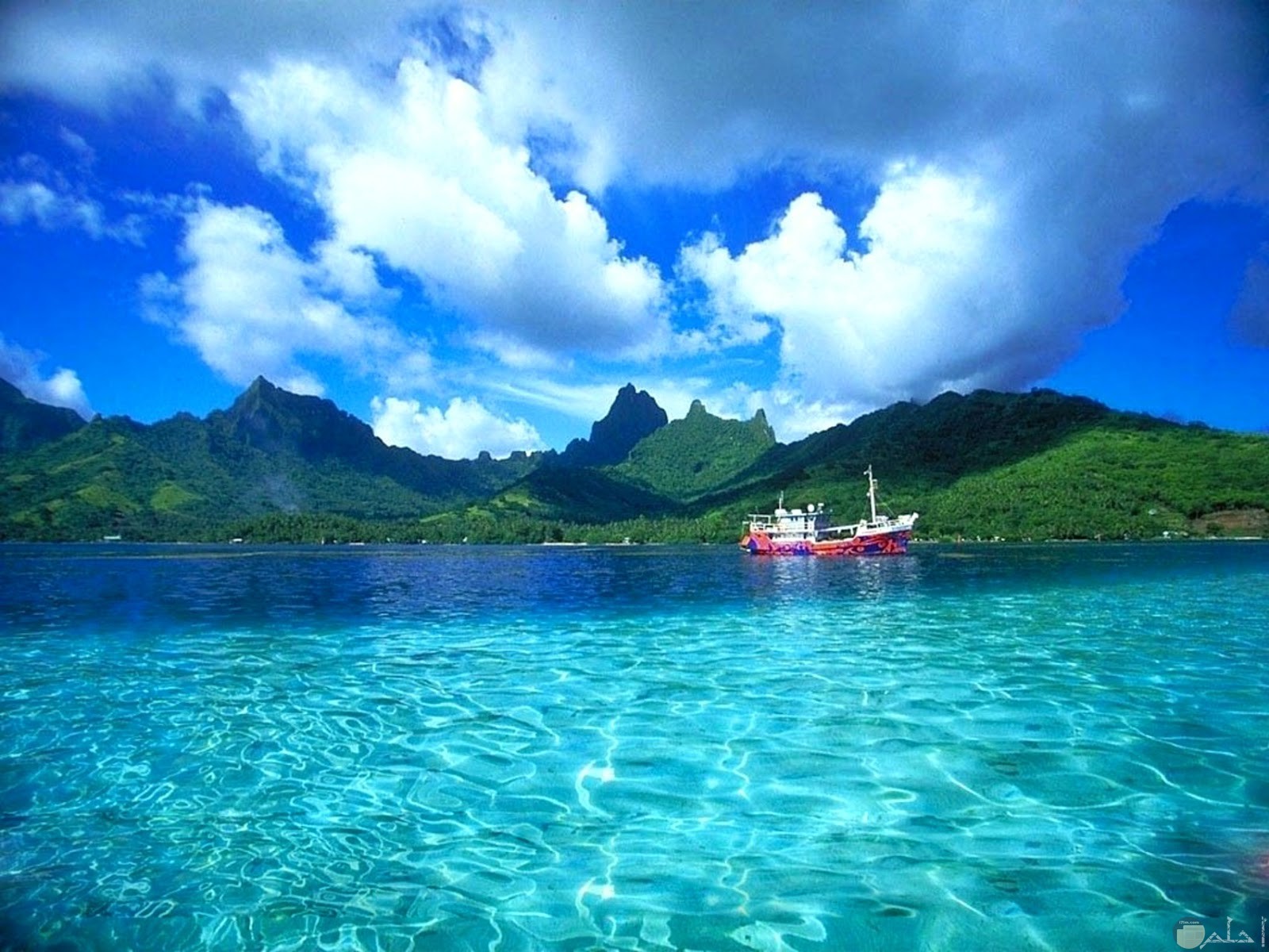 بحر له مياه صافية شفافة جميلة و جبال جزيرة تظهر من بعيد.