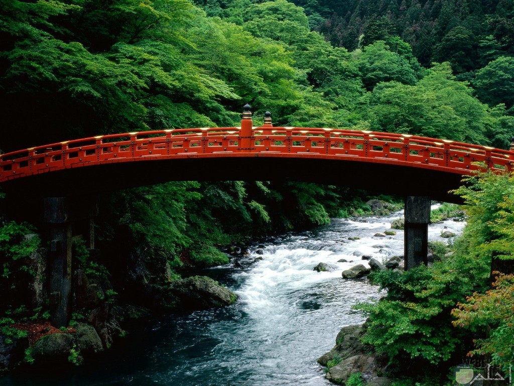 جسر باللون الاحمر فوق النهر و جمال الطبيعة.