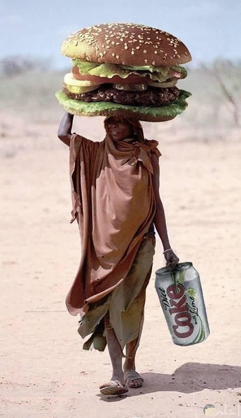 سيدة إفريقية تحمل فوق رأسها ساندويتش بورجر عملاق