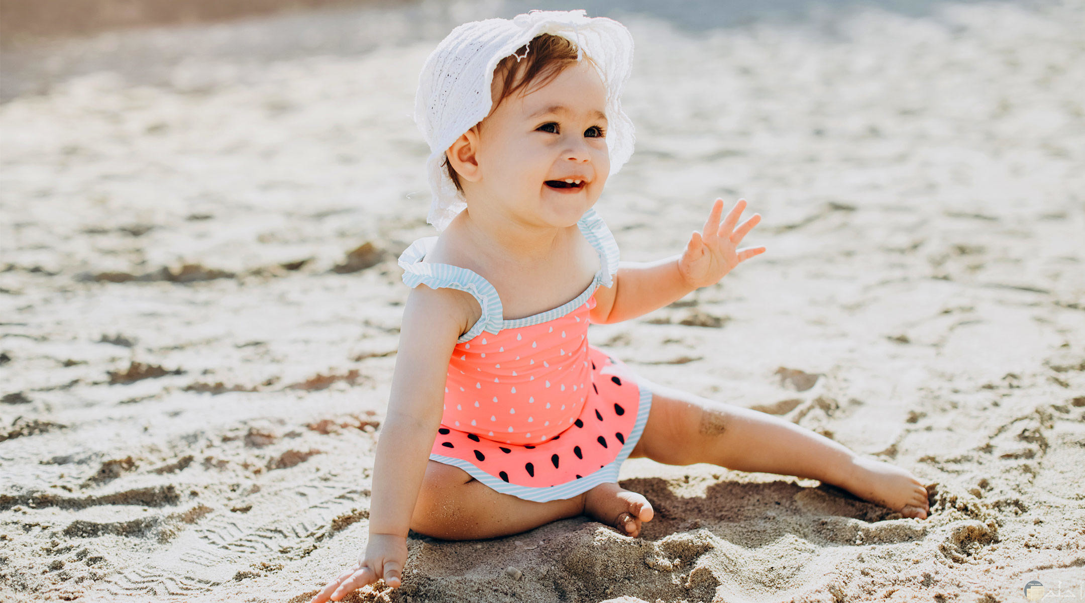 طفلة صغيرة على رمال الشاطئ.