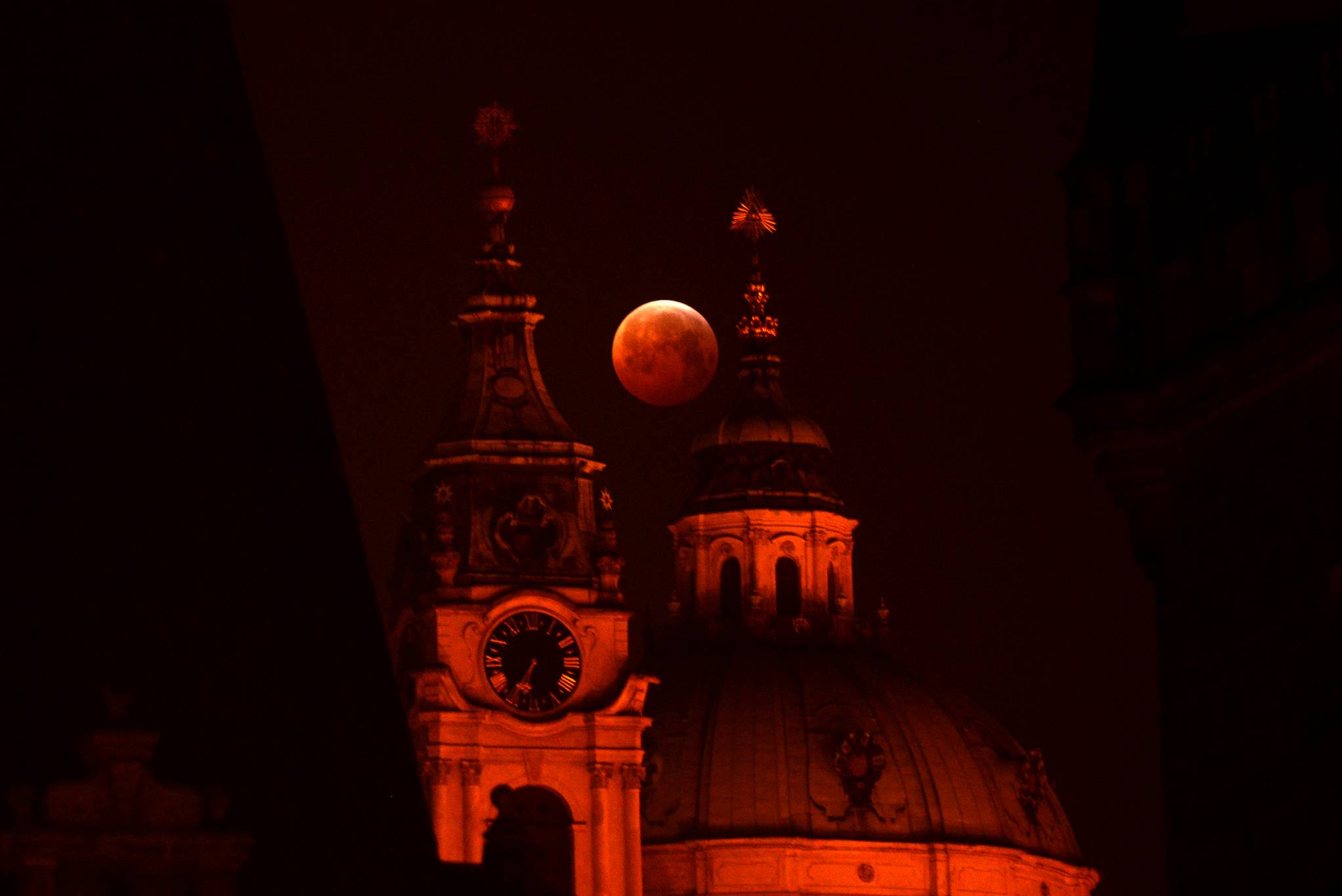 صورة للقمر الأحمر بين أعمدة مبني عملاق
