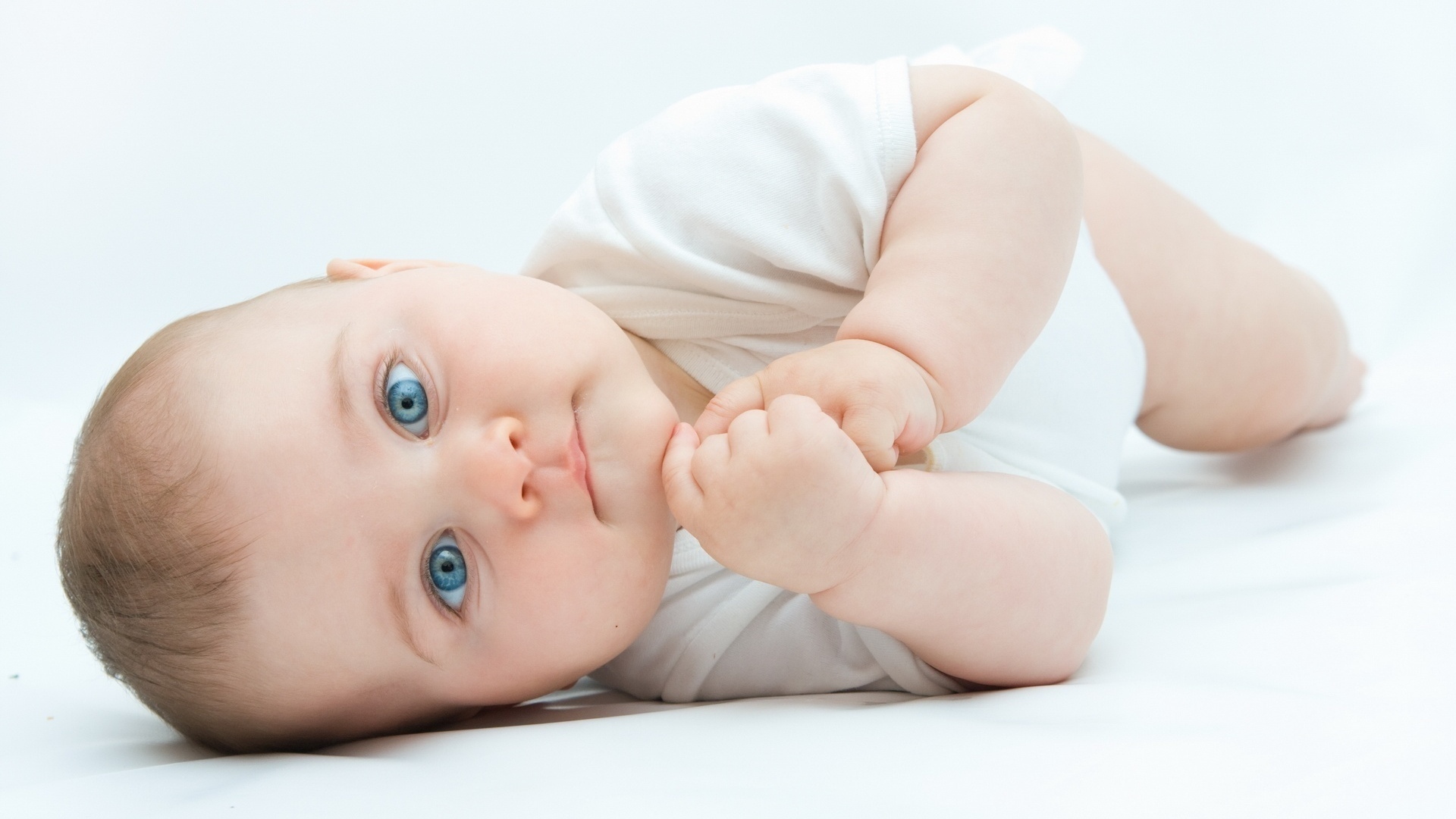 طفل صغير عيونه زرقاء وخلفية بيضاء
