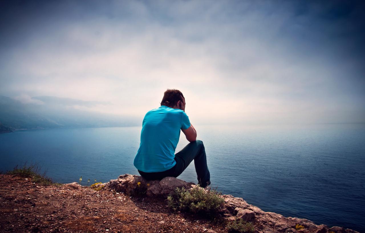 رجل جالس حزين أمام البحر