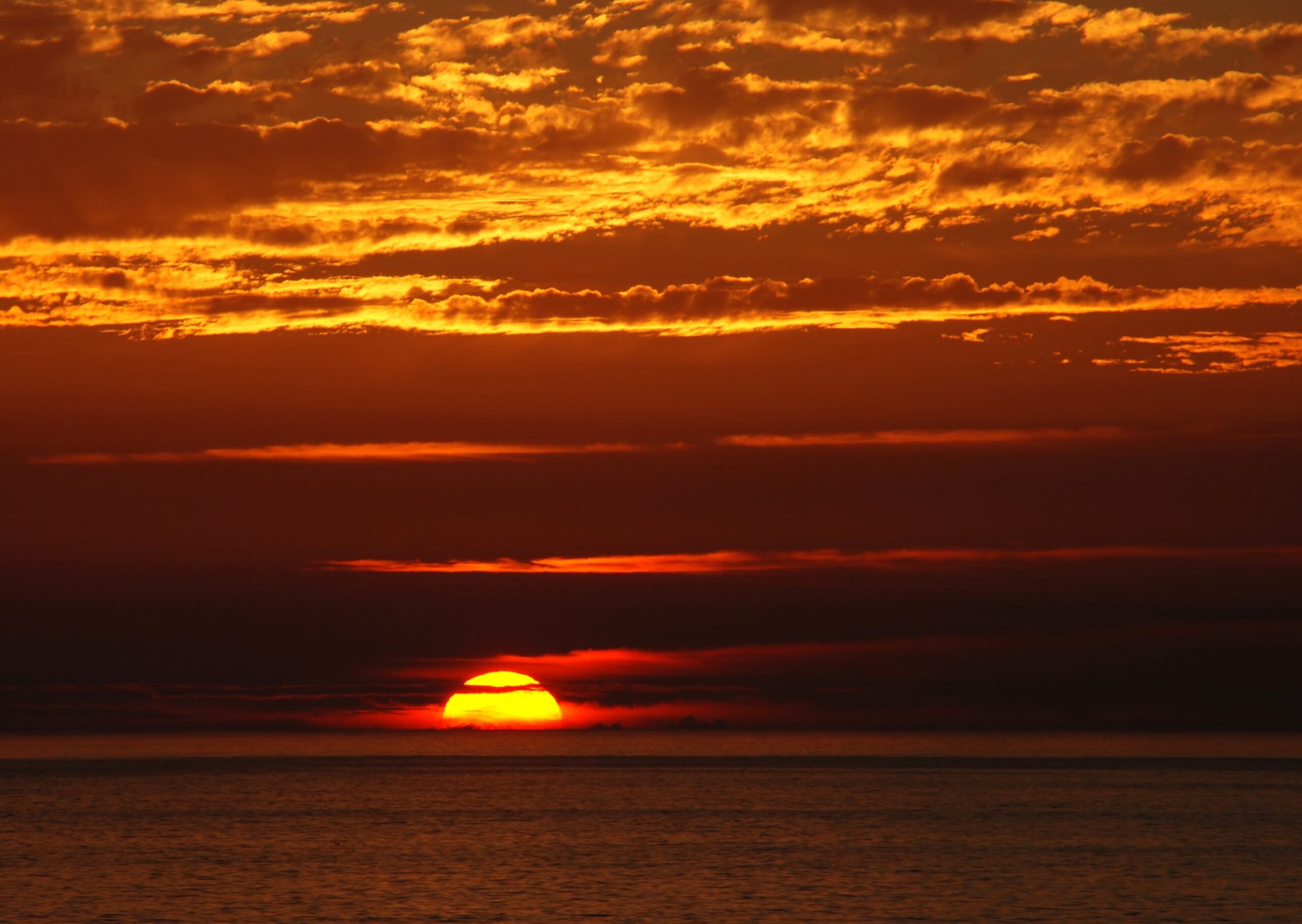 صورة غروب الشمس وسحب حمراء